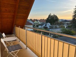 a balcony with a table and chairs and a view at Vienna's Nature Corner - charming rooftop family apartment in Gerasdorf bei Wien