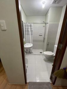La salle de bains est pourvue de toilettes, d'un lavabo et d'une douche. dans l'établissement Budget Room, à Cebu