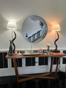 a table with two lamps and a large mirror at Smithgrove Guesthouse in Pietermaritzburg +50 photos