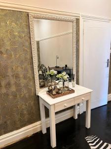 a dressing table with a mirror on a wall at Smithgrove Guesthouse in Pietermaritzburg