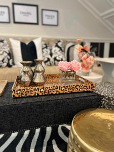 a table with vases and a tray with roses on it at Smithgrove Guesthouse in Pietermaritzburg