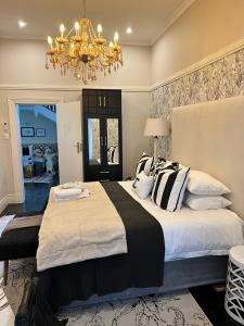 een slaapkamer met een groot bed en een kroonluchter bij Smithgrove Guesthouse in Pietermaritzburg