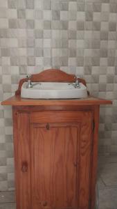 een wastafel in de badkamer bovenop een houten kast bij Jay's Guest House in Witbank
