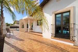 a house with a palm tree and a patio at Villa Merry in Ayia Napa