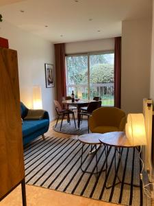 a living room with a blue couch and a table at Vue sur jardin, 3 pièces in Paris