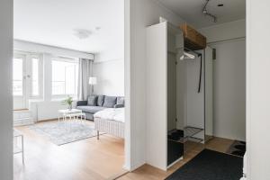 a white living room with a couch and a table at 2ndhomes Tampere "Koskenranta" Apartment - Sauna, Rooftop Terrace, Amazing Views & Free Parking in Tampere