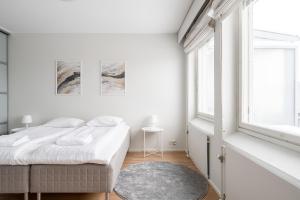 a white bedroom with a bed and a window at 2ndhomes Tampere "Koskenranta" Apartment - Sauna, Rooftop Terrace, Amazing Views & Free Parking in Tampere