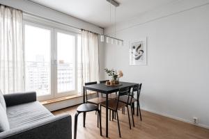 a living room with a black table and chairs at 2ndhomes Tampere "Koskenranta" Apartment - Sauna, Rooftop Terrace, Amazing Views & Free Parking in Tampere
