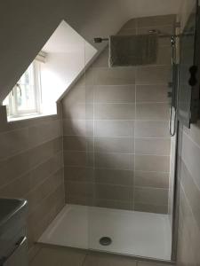 a shower with a glass door in a bathroom at Lane End Cottage in Ovington