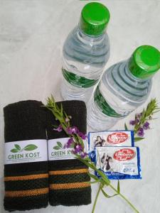 two bottles of water next to a towel and flowers at GreenKOST in Sintang