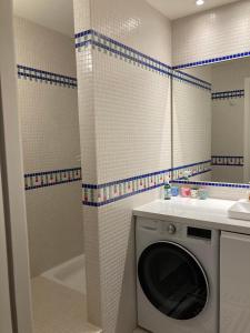 een badkamer met een wasmachine in een wastafel en een bad bij Vue sur jardin, 3 pièces in Parijs +14 foto's