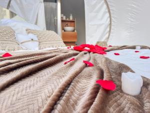 a blanket on a bed with red flowers on it at Bulles gonflables Love Room - Love Home XO in Richemont