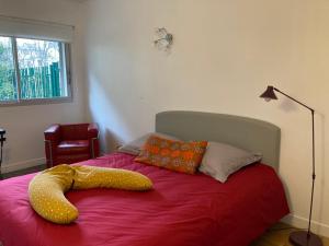 a bedroom with a bed with a yellow object on it at Vue sur jardin, 3 pièces in Paris