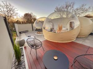 two domes on a patio with a table and chairs at Bulles gonflables Love Room - Love Home XO in Richemont