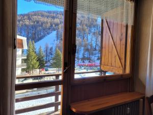une fenêtre avec vue sur une montagne enneigée dans l'établissement Over The Snow Apartment, à Borgata Sestriere