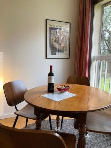 a table with a bottle of wine and a bowl on it at Vue sur jardin, 3 pièces in Paris