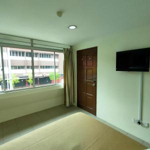 a room with a door and a television and a window at Best One Hotel in Melaka