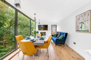 a dining room with a table and yellow chairs at The Keep at Castlegate - Luxury detached retreat in Cragg vale, Hebden Bridge in Mytholmroyd