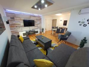 a living room with a couch and a table and a television at Apartment Pallaton in Našice