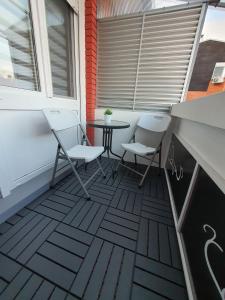 un patio con 2 sillas y una mesa en el balcón en Apartment Pallaton, en Našice