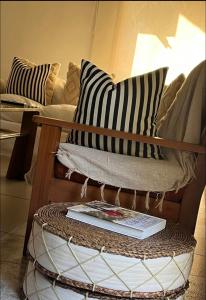 a couch with black and white pillows and a book at Casa Dash Beach Houses in Punta del Este