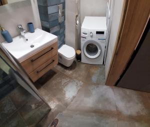 Un baño con lavadora y lavadora. en Buko apartamenty, en Uniejów