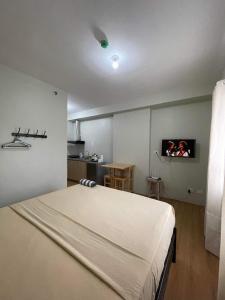 a bedroom with a bed and a tv on the wall at Budget Room in Cebu City