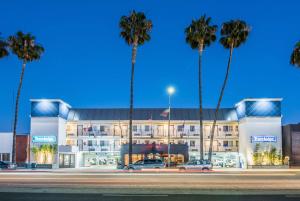 a building with palm trees in front of it at Travelodge by Wyndham Culver City in Los Angeles