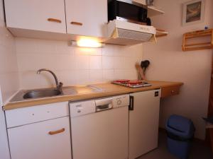 a small kitchen with white cabinets and a sink at Appartement Peisey-Vallandry, 2 pièces, 4 personnes - FR-1-411-78 in Landry