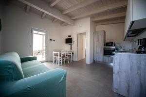 a living room with a green couch and a kitchen at Sunrise in Cipressa