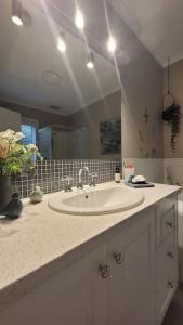 a bathroom with a sink and a large mirror at Quiet family retreat getaway - Wildlife Park, Sovereign Hill, Kryall Castle and city at your door - modern apartment, 8 guests in Ballarat