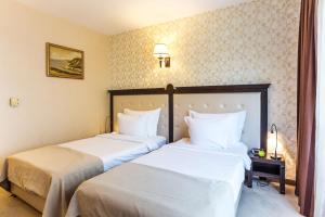 2 camas en una habitación de hotel con almohadas blancas en Best Western Lozenetz Hotel, en Sofía