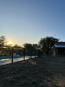 uma cerca ao lado de uma piscina com o pôr-do-sol ao fundo em Casa Grande Reservas por privado em San Javier