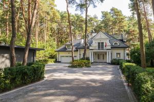 une maison dans les bois avec une allée dans l'établissement 4 Bedroom Peaceful Relaxation with outdoor wood-fired sauna and spa, à Magdalenka