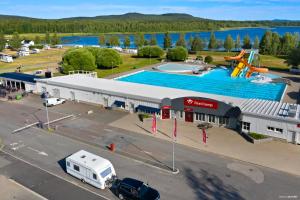 a large building with a swimming pool next to a parking lot at First Camp Björknäs-Boden in Boden