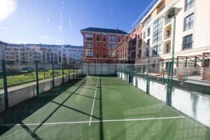 una pista de tenis en medio de un edificio en Apartagal-Urbanización Foz II, en Foz