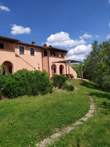 una casa con un patio de hierba delante de ella en Antonella House -Podere della Collina, en Palaia