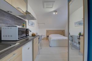 a kitchen with a microwave and a bed in a room at La petite maison 3 in Avoine