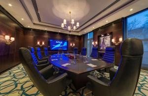 a conference room with a table and blue chairs at Radisson Blu Leogrand Hotel in Chişinău