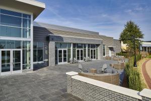 a patio in front of a building with chairs at Hyatt Place Wilmington Riverfront in Wilmington