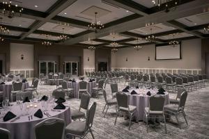 a banquet hall with tables and chairs and a screen at Hyatt Place Wilmington Riverfront in Wilmington