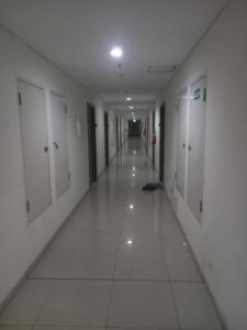 een lege hal met witte vloeren en witte deuren bij Northland ancol seaview in Jakarta