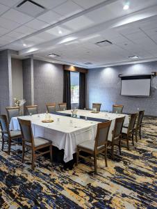a conference room with a table and chairs and a screen at Best Western Premier Route 97 Vernon in Vernon