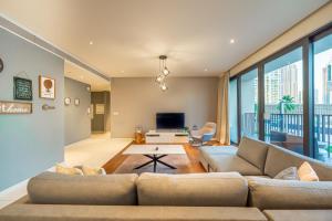 a living room with a couch and a tv at FAM Living - City Walk - Urban Staycations in Dubai