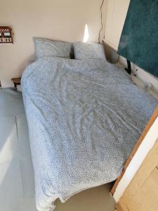 a bed with a blue blanket on it in a room at Esprit Péniche in Nantes