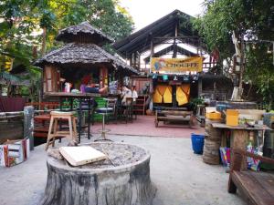 un negozio con un ceppo d'albero davanti di Pai River Jam Hostel & Campground a Pai