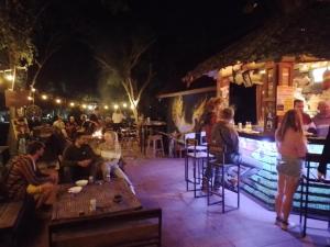 a group of people sitting around a bar at night at Pai River Jam Hostel & Campground in Pai