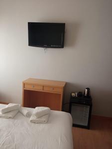a bedroom with a bed with a flat screen tv on the wall at Hostal Abami II in Madrid