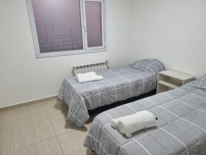 Habitación con 2 camas y ventana en rincon lindo en Cipolletti