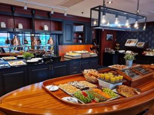a buffet line with food on a table in a restaurant at Grand Hotel Arendal - Unike Hoteller in Arendal